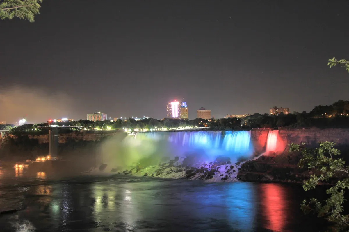 The American Falls illuminated at night on an evening Niagara Falls tour from Toronto